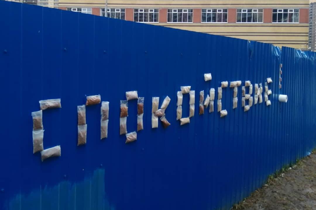 Петербургский уличный художник создал на строительном заборе инсталляцию из гречки и туалетной бумаги