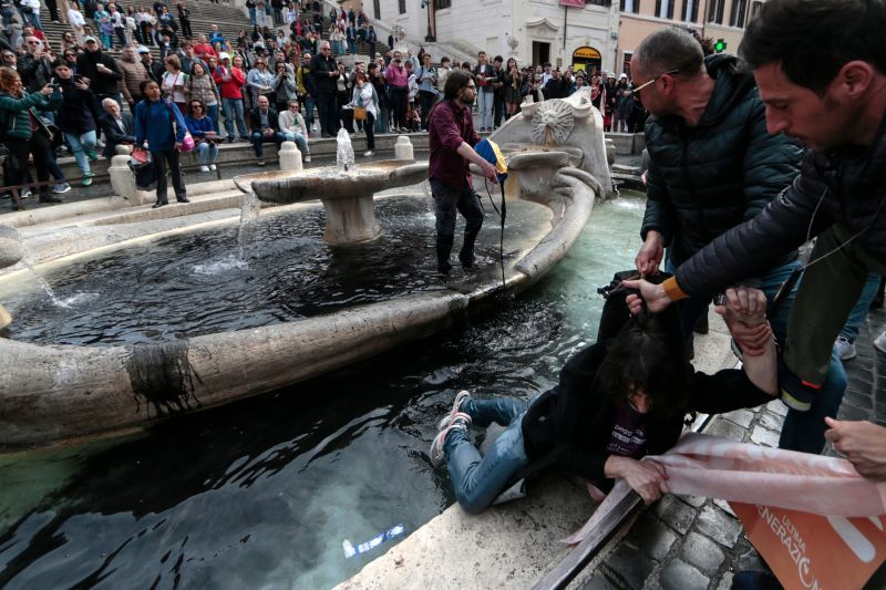 Экоактивисты продолжают борьбу за климат: в Риме они вылили в фонтан на площади черную краску